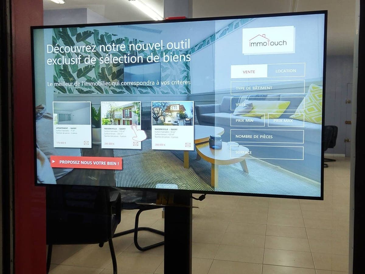 Écran et vitrine connectée humelab media en agence immobilière
